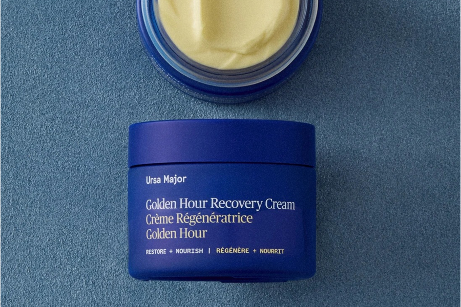 Rich face cream and face oil with a golden oil drop, a knitted glove and white winter berries on blush